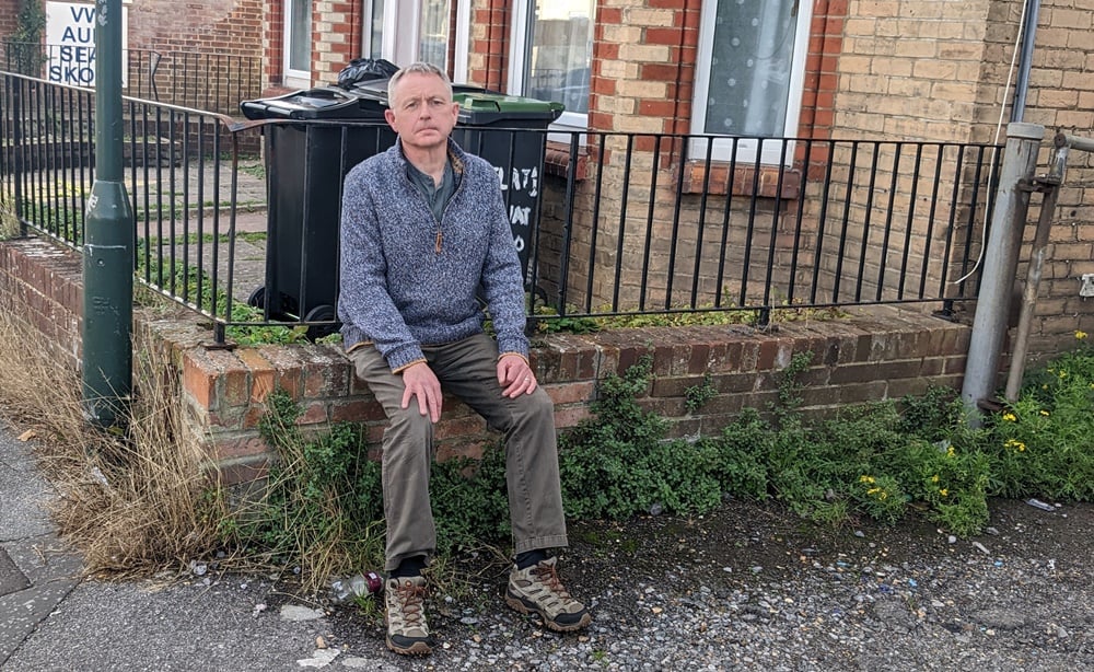 Simon Bull next to pavement weeds in Waterloo Road, Winton